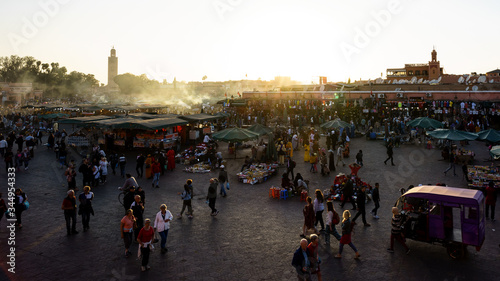 Marrakesh, Morocco - 04/05/2018: Tourists visiting Place Jemaa el Fna at sunset