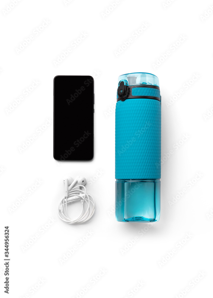 Flat lay top view blue bottle of water, headphones and smartphone isolated on white background Flat lay top view blue bottle of water, headphones and smartphone isolated on white background