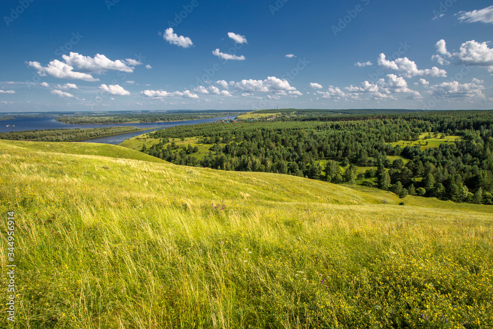Obraz premium hills overgrown with grass and trees on the banks of the Vyatka River