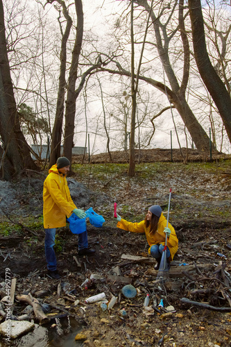 People in yellow raincoats sorting plastic garbage