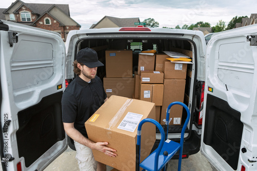 Shipment: Man Getting Boxes Out Of Delivery Van photo