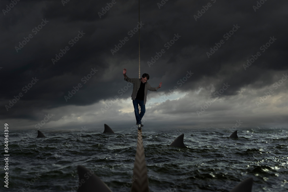 Tightrope balances on a rough sea full of sharks - obrazy, fototapety, plakaty 