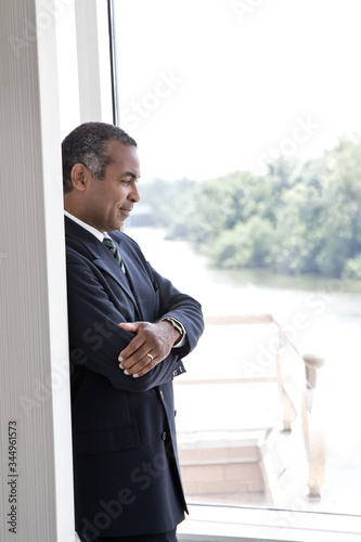 Thoughtful senior businessman looking through window in office