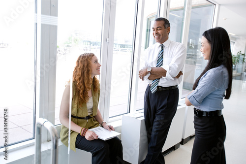 Smiling businessman and businesswoman talking in office