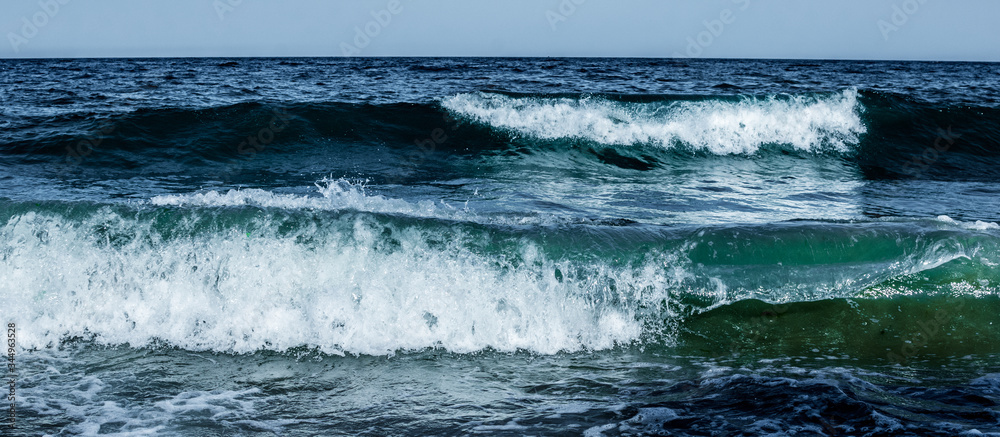 Fototapeta premium Summer. Sea. Sandy beach and fine sand. Small waves. Background.