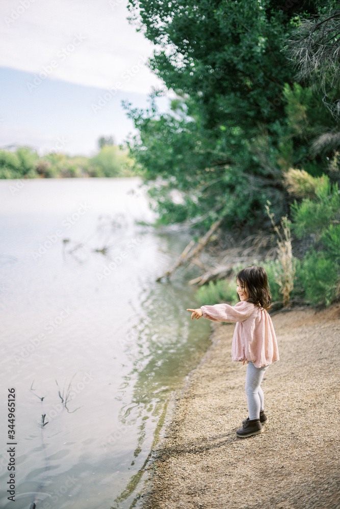 Young girl throwing rocks in lake Young girl throwing rocks in lake