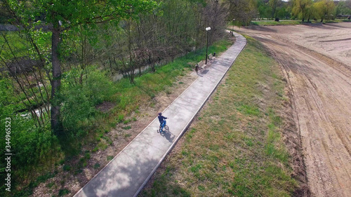 boy riding in a Park on the blue bike with side wheels