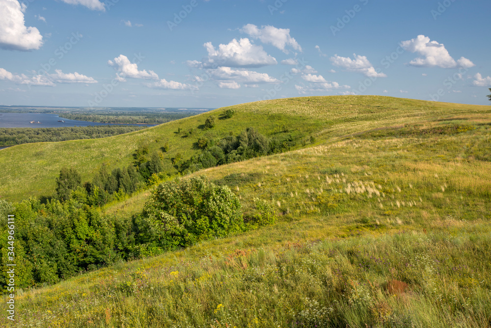Fototapeta premium hills overgrown with grass and trees on the banks of the Vyatka River