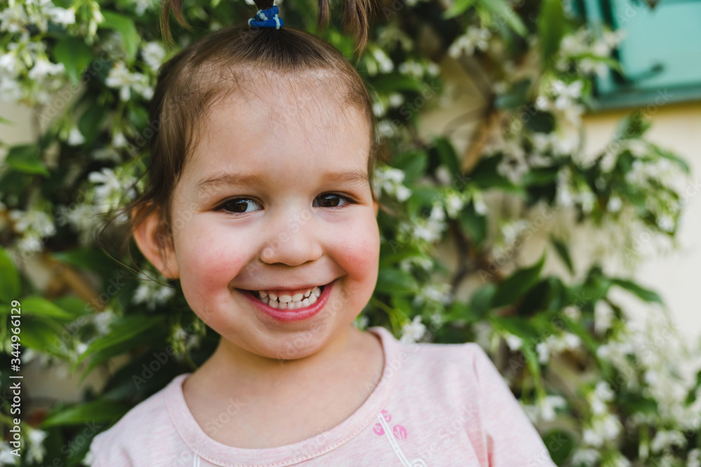 Smiling Toddler Girl in front of a Plant Smiling Toddler Girl in front of a Plant