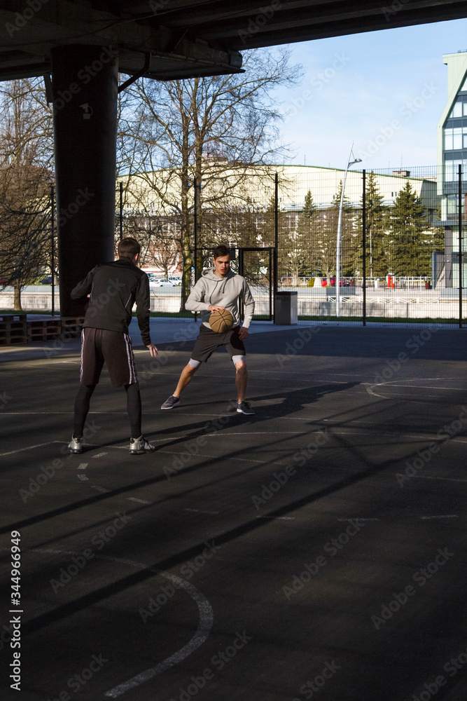Male friends playing basketball together