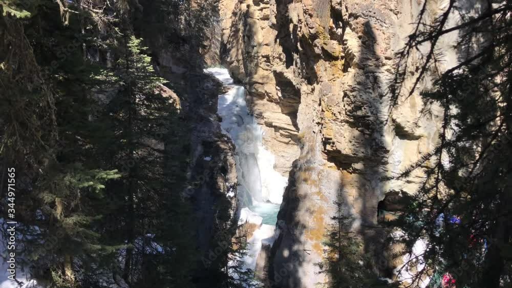 Frozen Waterfall is Starting to Melt in the Distance. Johnston Canyon in Banff, Alberta, Canada. Frozen Waterfall is Starting to Melt in the Distance. Johnston Canyon in Banff, Alberta, Canada.