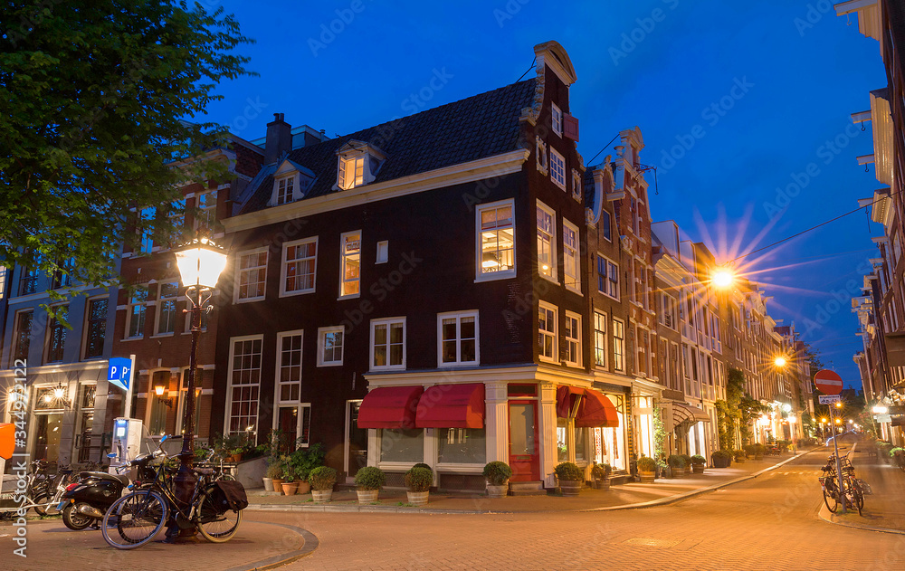 Night city view of Amsterdam bridge and typical dutch houses, Holland.
