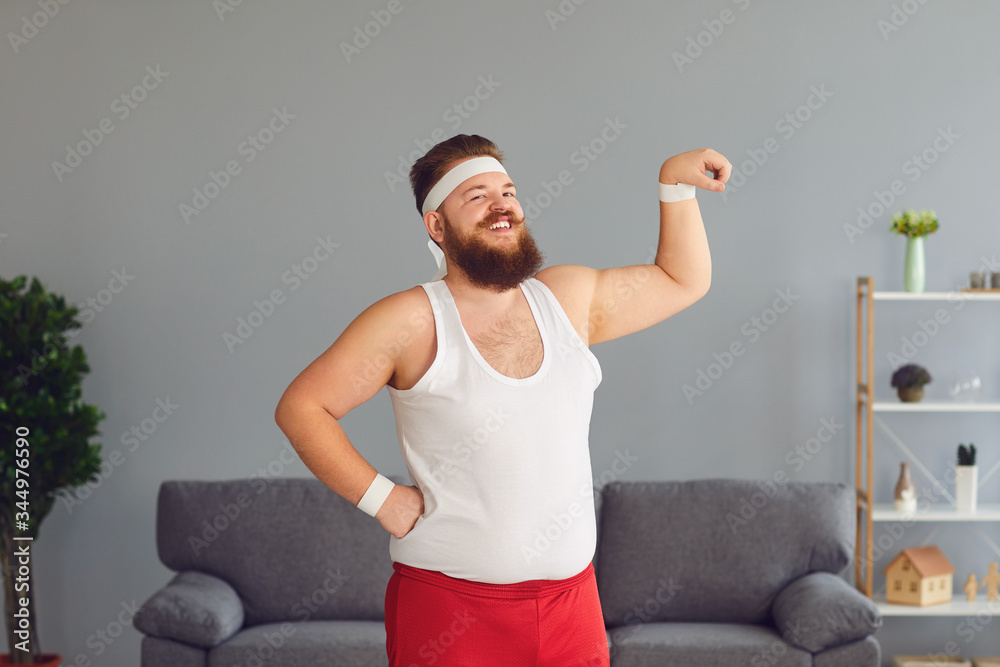 Funny fat man in red shorts and white tshirt smiling doing exercises