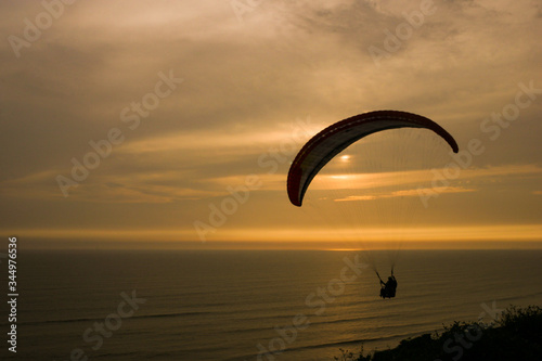 personas volando en parapente sobre el mar