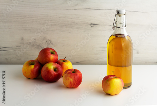 A glass bottle of apple juice, cider, vinegar