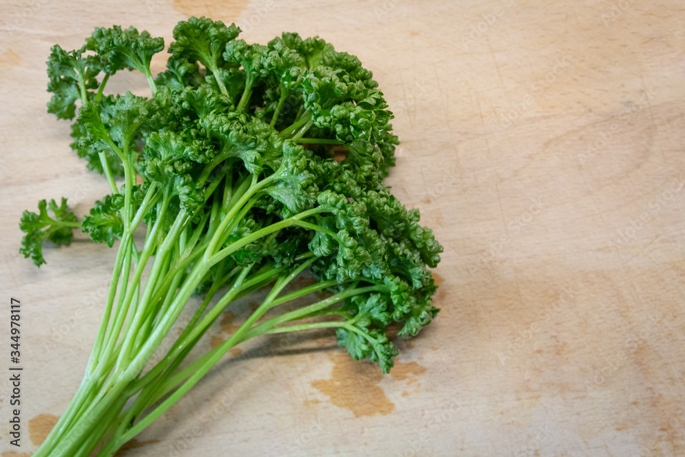 A bunch of parsley on a wooden board A bunch of parsley on a wooden board
