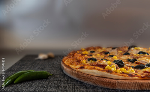 Delicious pizza surved on wooden plate. photo