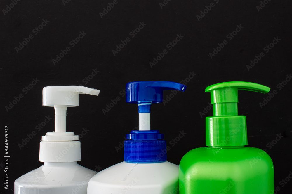 Shampoo colorful bottles top on a black background Shampoo colorful bottles top on a black background