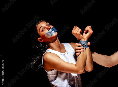 Scared abuse victim being attacked by a mad man in a dark place. man beat sad woman. People. Family problem. Dark background. Conflict. Femele. Help me. Help. Couple. Background. Hands concept.
 photo