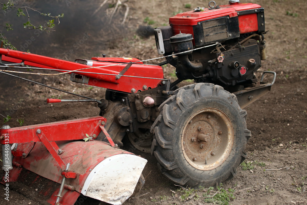 a walk-behind tractor in a field a walk-behind tractor in a field