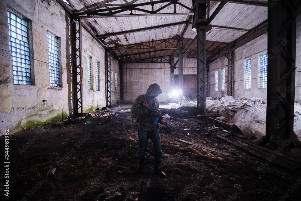 Rebel inmask armed with AK in destroyed factory