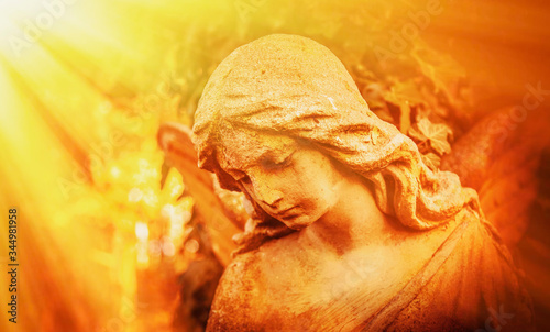 Beautiful sad angel in direct sunlight. Vintage styled image of ancient statue.(religion, faith, death, resurrection, eternity concept) © zwiebackesser
