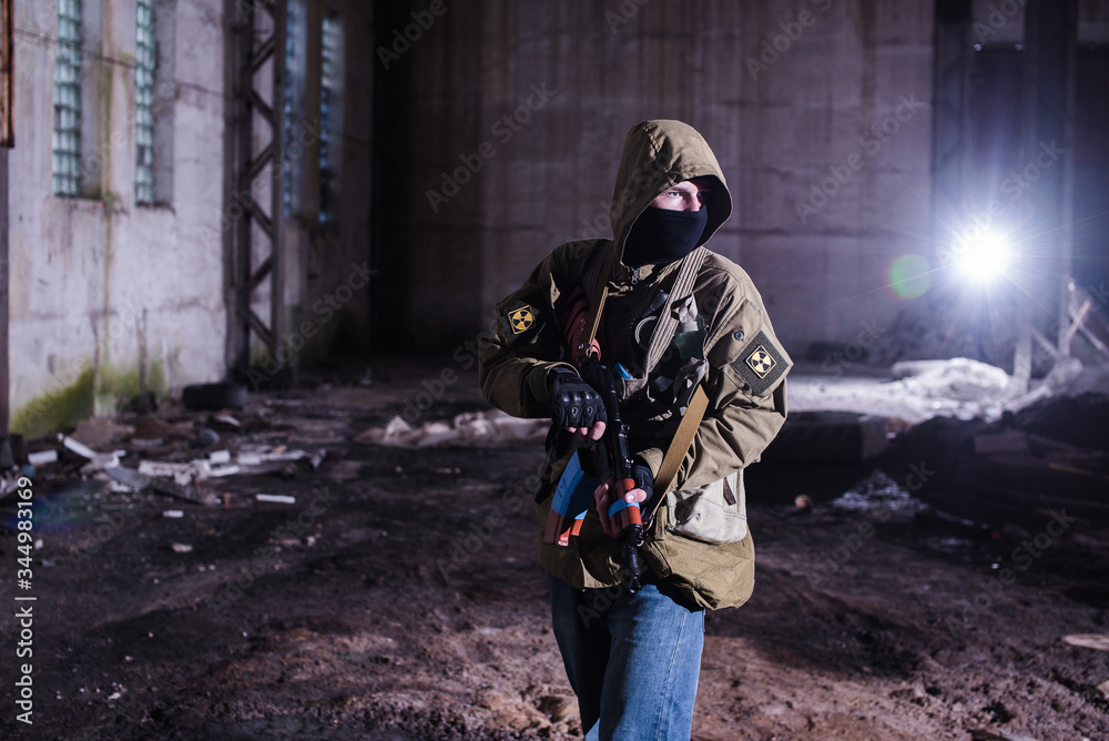Fototapeta premium Armed stalker warrior in destroyed hangar