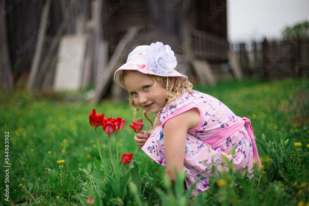 Fototapeta premium little girl playing with flowers