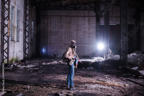 Armed stalker warrior in gas mask in destroyed hangar © yurbeck