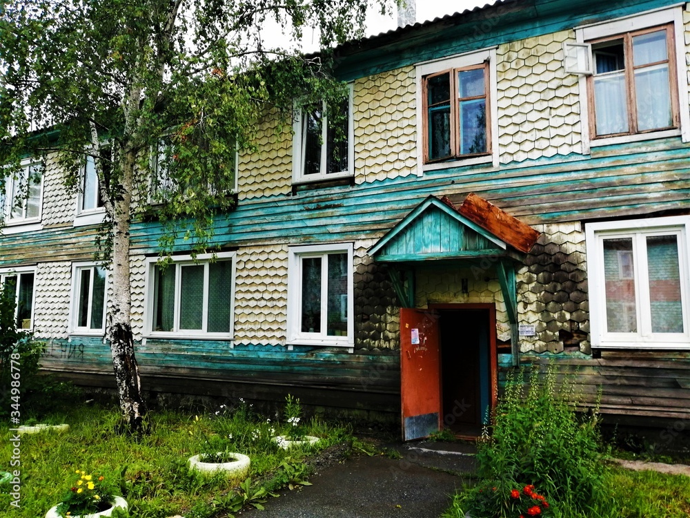 Two-story wooden house in a rainy weater with an open door.Russia. Two-story wooden house in a rainy weater with an open door.Russia.
