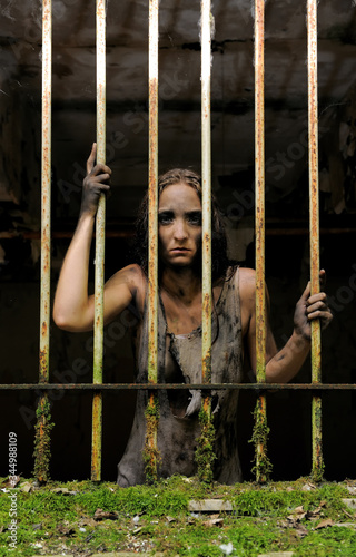 A psychopathic woman is seen in jail. She is
filthy and her clothes are rags. Her expression
is scary and shows she has a disorder. 