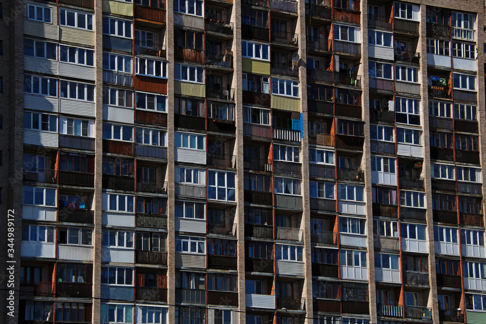 loggias of a tall brick apartment building in a residential area of the city