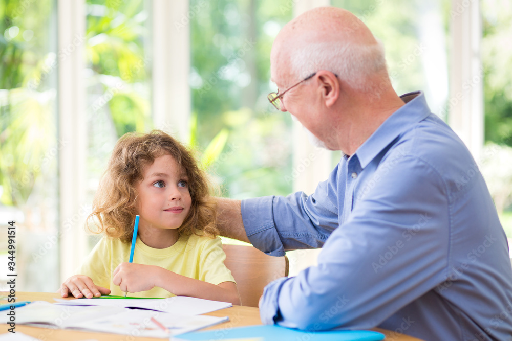 Grey grandfather and his cute grandson do homework Grey grandfather and his cute grandson do homework