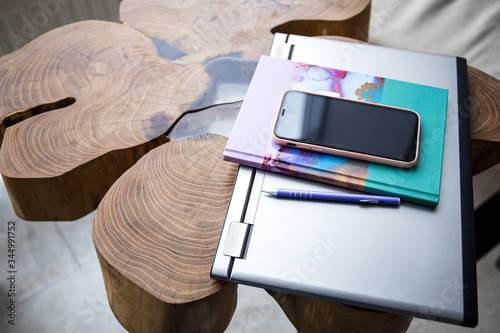 Laptop, diary, phone and pen on a wooden table