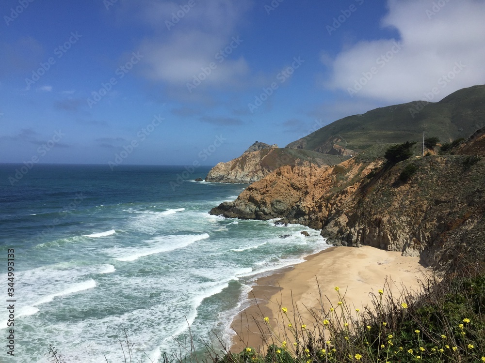 Montara State Beach, California, Pacific Coast Highway 1 - Backdrop of California mountains and the Pacific Ocean with the crashing waves washing up on the beach