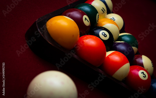 Close up of billiard balls racked in a triangle on a red felt pool table