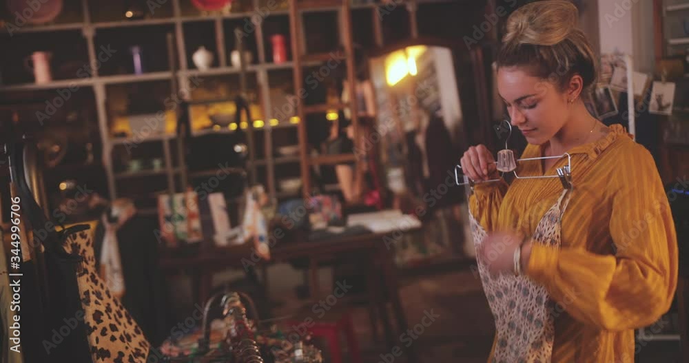 Blonde woman shopping for swimsuits in a vintage boutique store