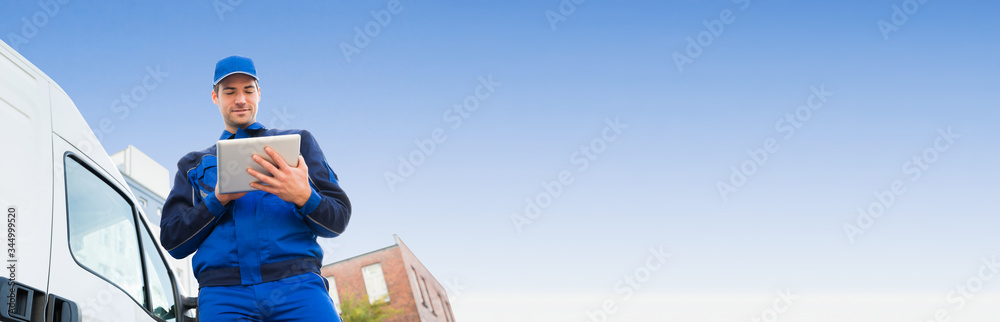 Delivery Man Using Digital Tablet By Truck Against Sky Delivery Man Using Digital Tablet By Truck Against Sky