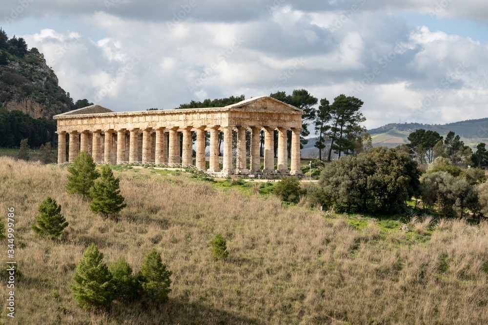 Landscape with ancient Doric temple of Segesta in sunny spring day with cloudy sky