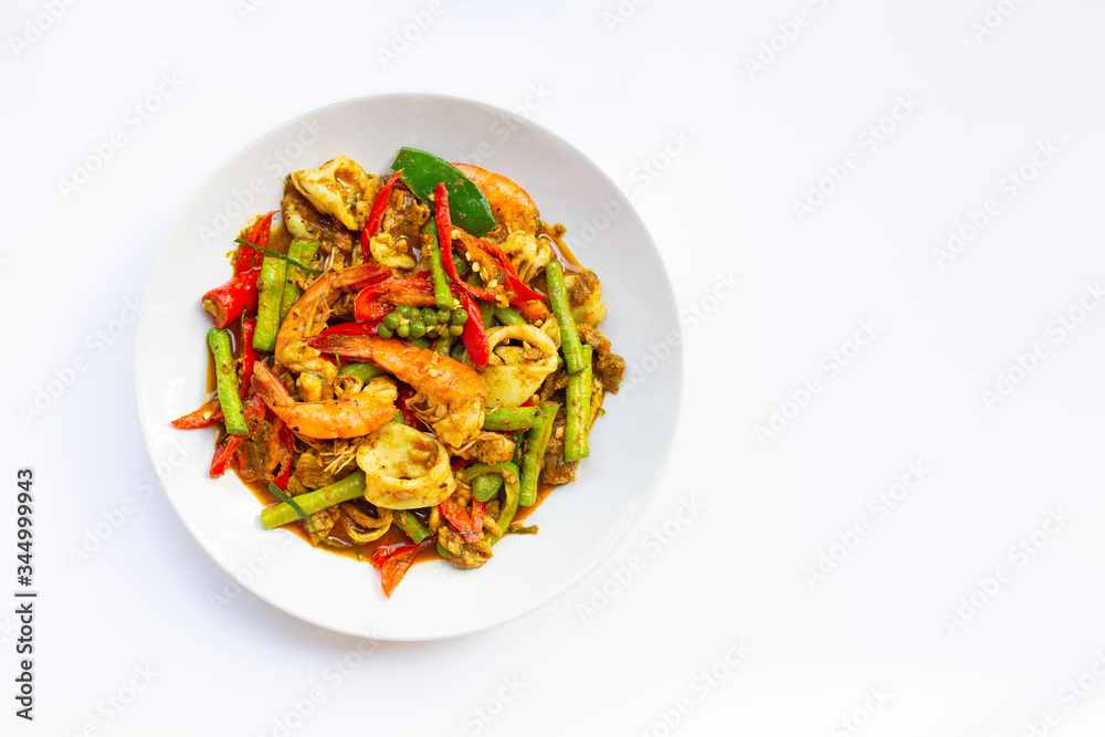 Spicy stir fried shimp, squid and pork with Thai Southern chili paste and longbean on white background. Spicy stir fried shimp, squid and pork with Thai Southern chili paste and longbean on white background.