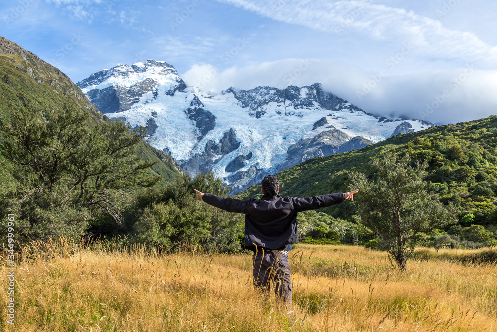 Man with open arms during at Mount Cook, New Zealand ..