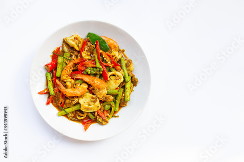Spicy stir fried shimp, squid and pork with Thai Southern chili paste and longbean on white background.