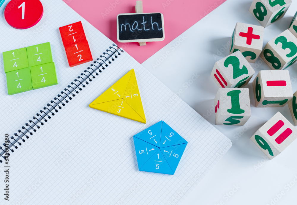 Colorful math fractions, notebook on blue pink white background. Interesting, fun mathematics for kids. Education, back to school concept Colorful math fractions, notebook on blue pink white background. Interesting, fun mathematics for kids. Education, back to school concept