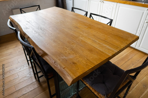 Fotografie A big wooden dining table with glass blocks and metal wicker chairs and pillows