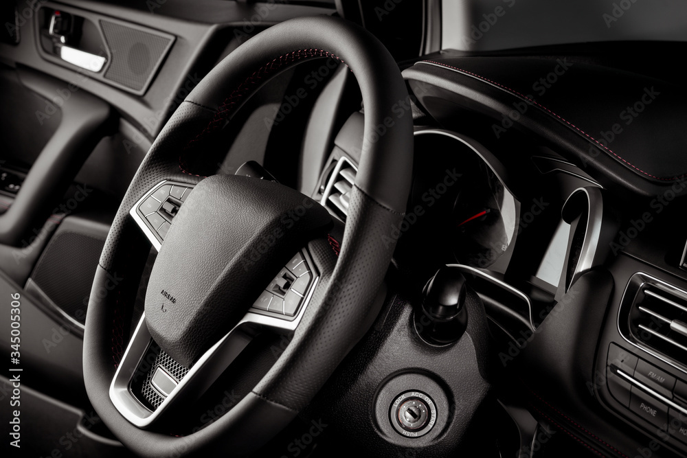 Steering wheel inside a new and modern car for sale, with luxurious details - dark light