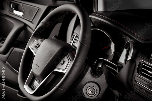 Steering wheel inside a new and modern car for sale, with luxurious details - dark light © JesusCarreon