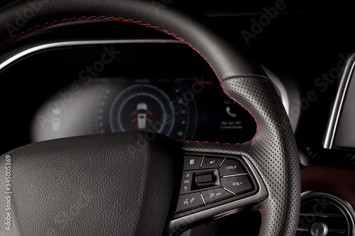 Interior modern car with new technology, leather steering wheel and digital speedometer display
