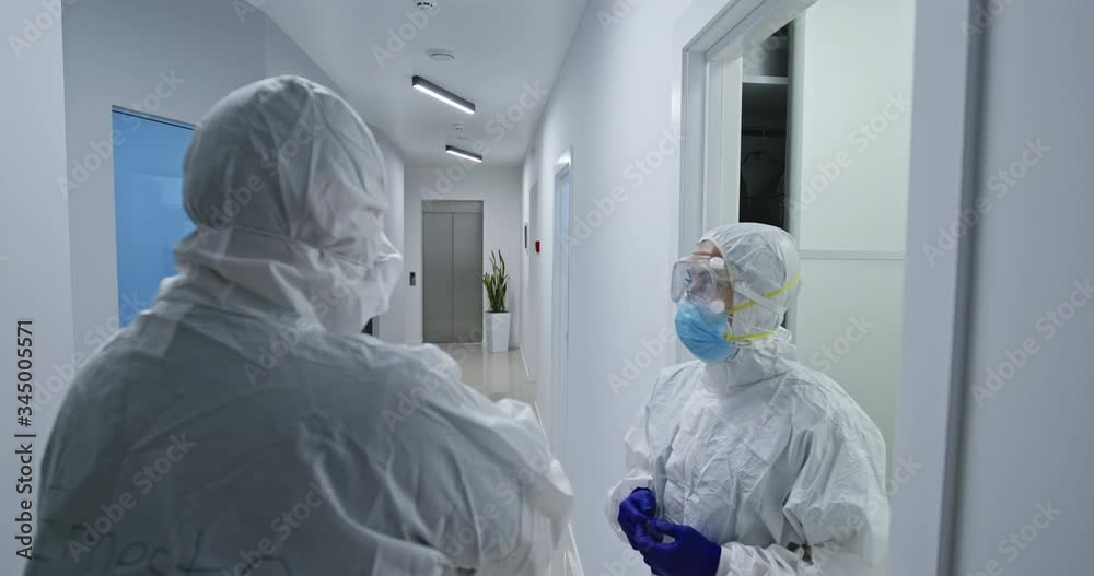Front view close up of a mixed race female and a mixed race male healthcare professional wearing a surgical caps and masks in a hospital. Healthcare workers in the Coronavirus Covid19 pandemic.