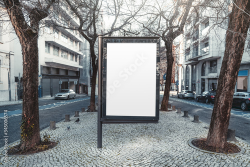 Mockup of an empty information poster in urban settings near city roads; a blank vertical street banner template on the sidewalk in alleyway; an outdoor billboard placeholder mock-up inside the alley