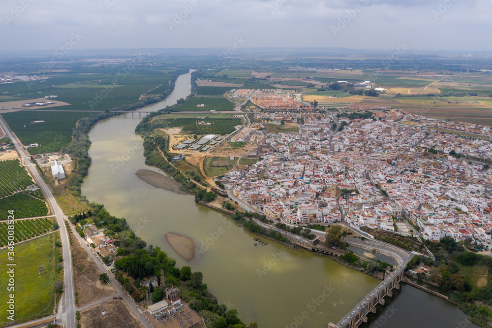 Aerial drone shot of a beautiful town in spain with river flowing 